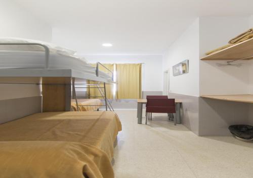 1 dormitorio con litera y mesa en Albergue Inturjoven Malaga, en Málaga