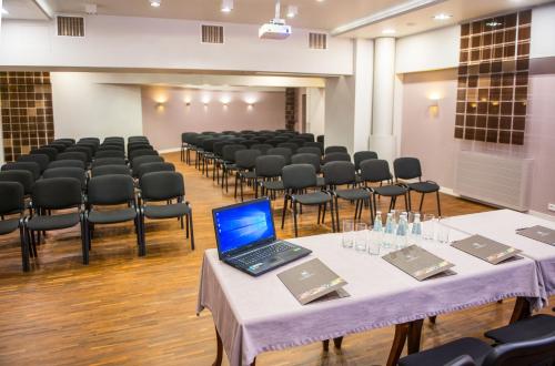 a room with tables and chairs with a laptop on them at Hotel Kazimierzówka in Kazimierz Dolny