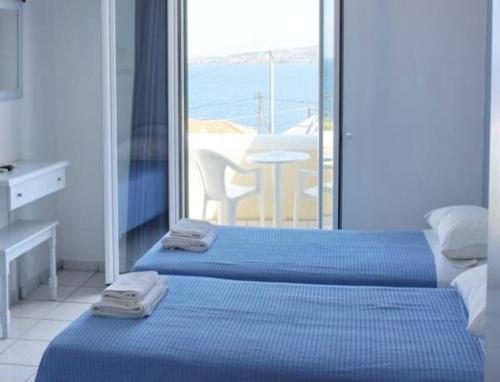 two beds in a room with a view of the ocean at Alvi Studios in Perdika