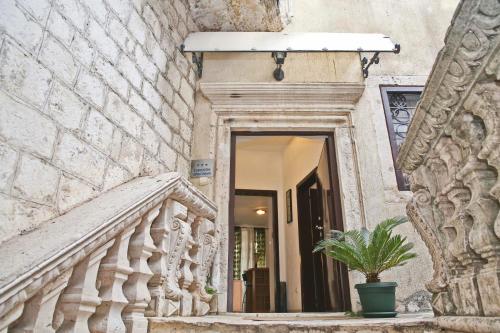 a building with a staircase and a potted plant at Old town Kotor Square in Kotor