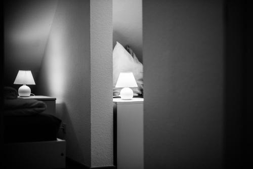 two lamps on a night stand in a bedroom at Gästehaus Villa Rose in Dürrröhrsdorf