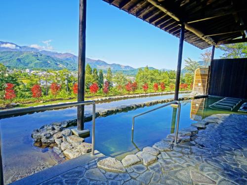 a resort pool with a view of the mountains at Hakuba Highland Hotel in Hakuba