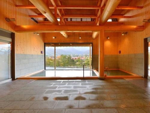 a large room with a pool and a large window at Hakuba Highland Hotel in Hakuba