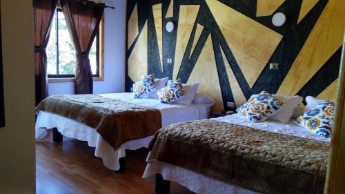 a bedroom with two beds and a window at Residencial del Maule in Linares