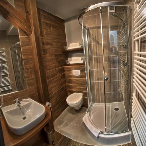 a bathroom with a shower and a sink and a toilet at Hotel Górecznik in Ostrów Wielkopolski