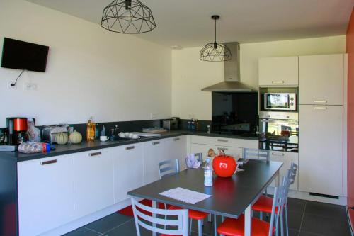 - une cuisine avec une table, des chaises et un comptoir dans l'établissement domaine un jour parfait, à Rostrenen