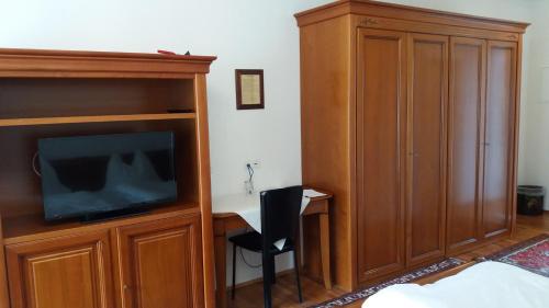 a bedroom with a bed and a tv and a desk at Hotel Gratkorn - "Bed & Breakfast" in Gratkorn
