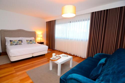 een woonkamer met een bank en een bed bij Casas do Forte do Pico in Funchal