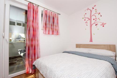 1 dormitorio con 1 cama con cortinas rojas y ventana en Apartment Ilinović, en Rovinj