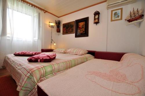 a bedroom with two beds and a window at Apartmani Etica in Postira
