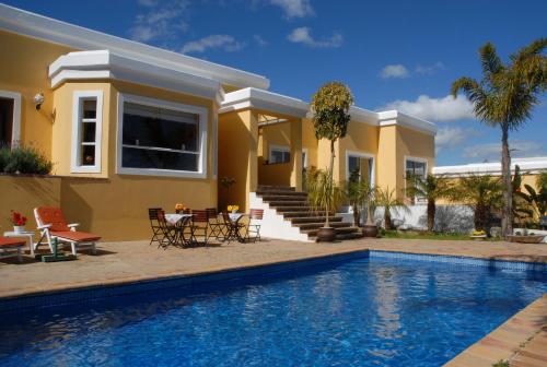a house with a swimming pool in front of a house at Big6 Guesthouse in Somerset West