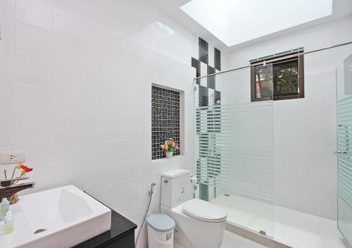 uma casa de banho branca com um WC e um lavatório em Victoria Villa II em Praia de Jomtien