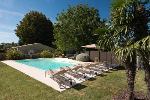 uma piscina com espreguiçadeiras ao lado de uma piscina em Le Moulin de Beaunette em Grane