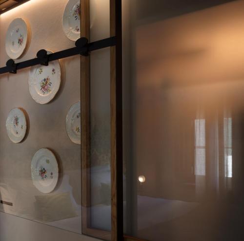 a display of plates on a wall with a mirror at Ottantotto Firenze in Florence