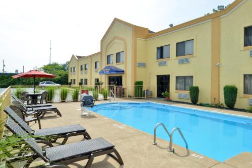 a swimming pool with patio furniture and a building at Best Western Port Clinton in Port Clinton