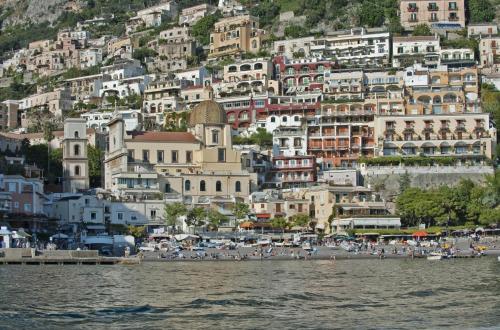 a group of buildings on a hill next to the water at Villa La Tartana in Positano