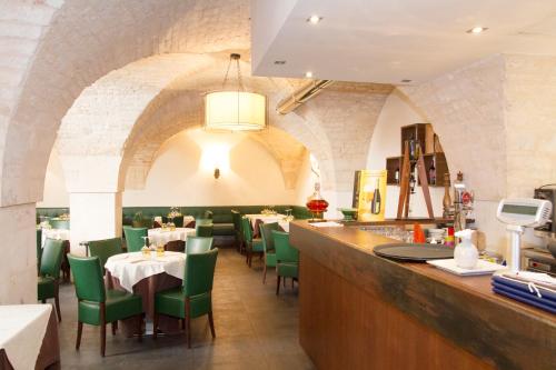 a dining room with green chairs and a bar at Hotel Lanzillotta in Alberobello