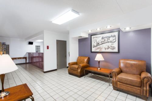 a waiting room with two chairs and a table at Super 8 by Wyndham Springdale AR in Springdale