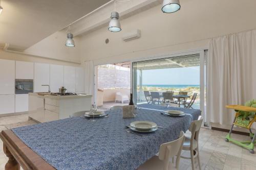 a kitchen and dining room with a blue table and chairs at Villa Unica Terrazzo Sul Mare in Donnalucata