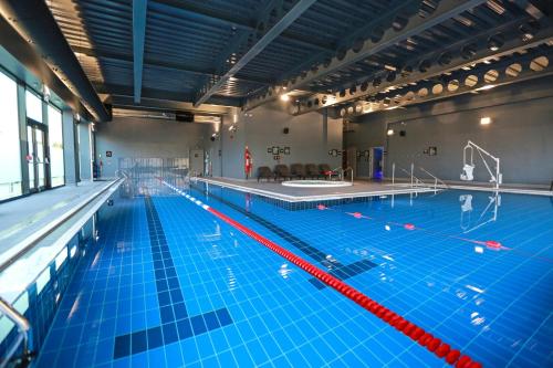 a large indoor swimming pool with blue water at Village Hotel Portsmouth in Portsmouth