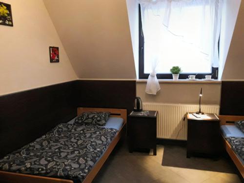 a bedroom with two beds and a window at Pokoje Gościnne z łazienkami przy Wrocławiu, darmowy parking in Długołęka