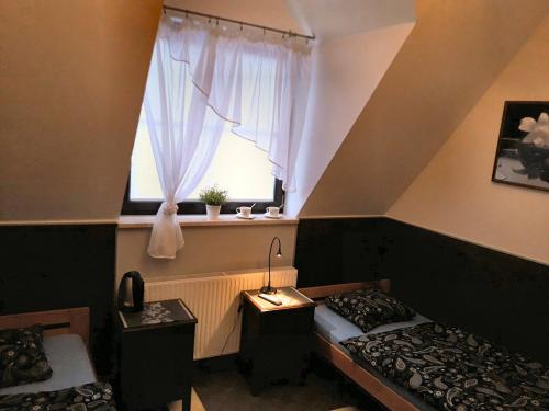 a room with two beds and a window at Pokoje Gościnne z łazienkami przy Wrocławiu, darmowy parking in Długołęka