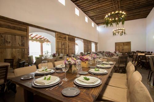 ein Esszimmer mit einem langen Holztisch und Stühlen in der Unterkunft La Casona Del Banco Hotel Boutique in Parras de la Fuente