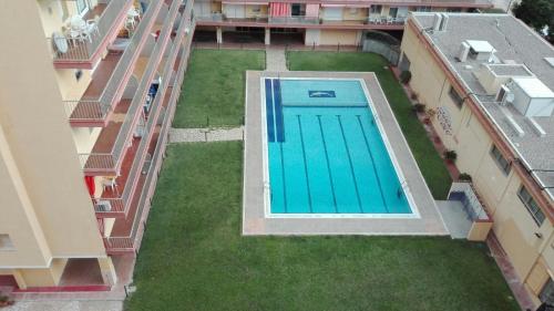 an overhead view of a swimming pool on a lawn between two buildings at Apartaments Players in Malgrat de Mar