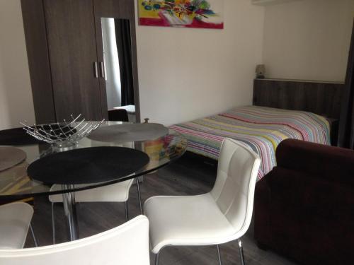 Pokój z dwoma stołami i krzesłami oraz łóżkiem w obiekcie Studio de la Halle. w mieście Figeac