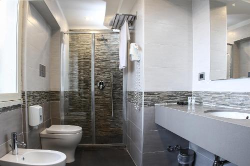 a bathroom with a shower and a toilet and a sink at Best Western JFK Hotel in Naples