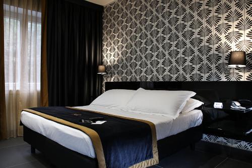 a bedroom with a bed with a black and white wallpaper at Best Western JFK Hotel in Naples