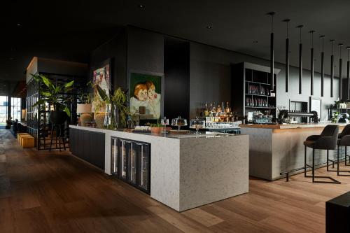 a bar with a counter and chairs in a room at Van Der Valk Luxembourg Arlon in Arlon