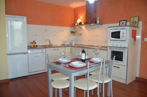 a kitchen with a table with chairs and a bottle of wine at Casa Emma in Villamarciel