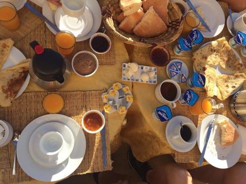 a table filled with food and cups of coffee at Dar Es Salam in Skoura