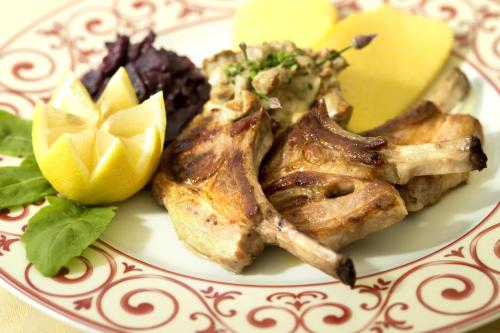 a plate of food with chicken and vegetables and a lemon at Hotel Bergblick in Racines