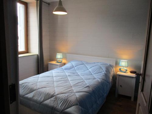 ein Schlafzimmer mit einem Bett und zwei Tischen mit Lampen in der Unterkunft L'estaou in Lavoûte-Chilhac