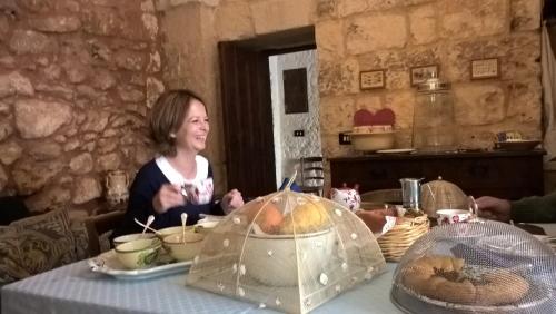 a woman is sitting at a table with a table cloth at Casale del Forno in Andrano