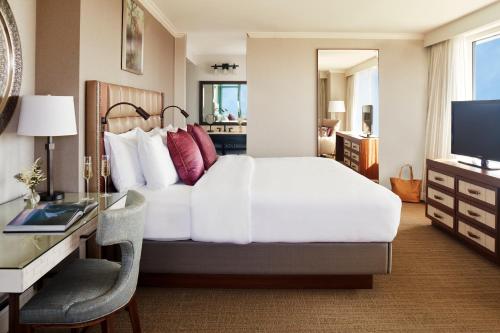 a bedroom with a bed and a desk and a television at Lansdowne Resort and Spa in Leesburg