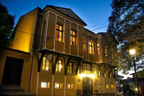 un vieux bâtiment avec des lumières allumées la nuit dans l'établissement Guest House Old Plovdiv, à Plovdiv
