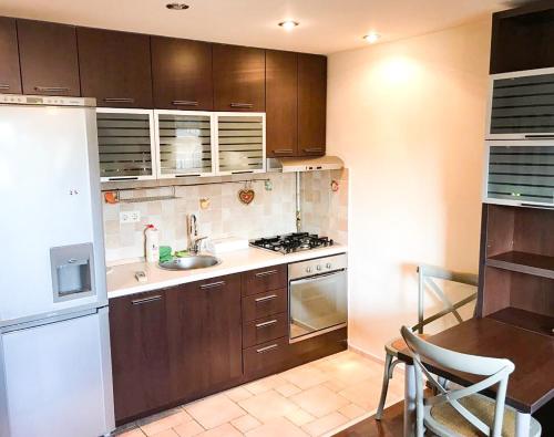 a kitchen with wooden cabinets and a white refrigerator at Cozy Flat in Villa Near Old Town in Bucharest