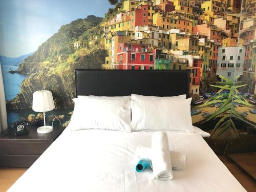 a bedroom with a bed with a painting of a city at VORTEX SUITES KLCC by PNUT With NETFLIX in Kuala Lumpur