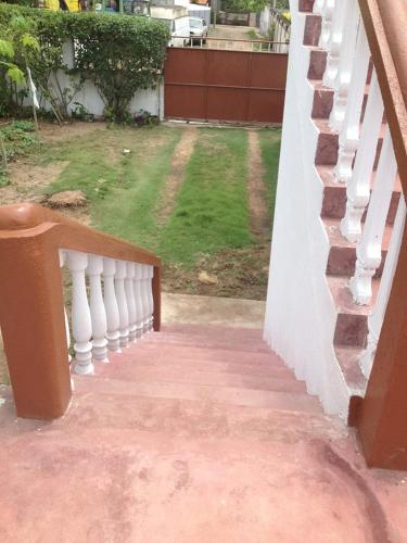 a porch with a white railing and a grass yard at VIP House-Praia Francesca in São Tomé
