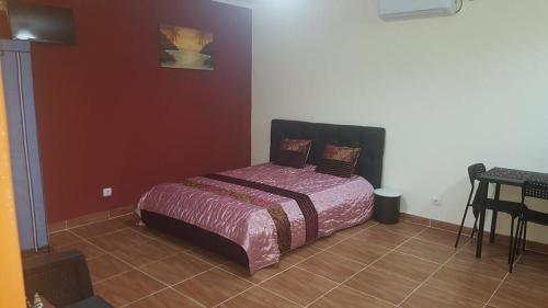 a bedroom with a bed in the corner of a room at VIP House-Praia Francesca in São Tomé