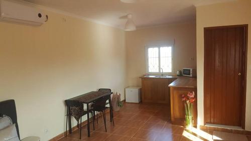 a kitchen with a table and chairs in a room at VIP House-Praia Francesca in São Tomé