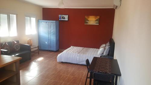 a bedroom with a white bed and red walls at VIP House-Praia Francesca in São Tomé