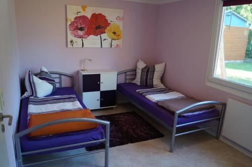 a bedroom with two beds and a window at Ferienhaus am Luckower See in Sternberg