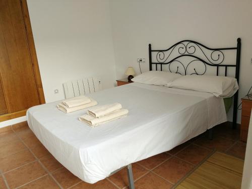 ラス・ネグラスにあるApartamento Los Olivosのベッドルーム1室(白いベッド1台、タオル2枚付)