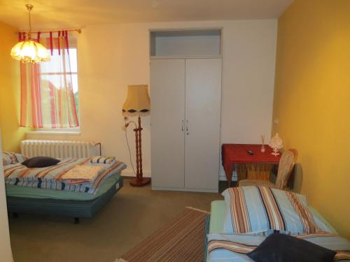 een woonkamer met 2 bedden en een tafel bij Zimmervermietung zum See in Wolteritz