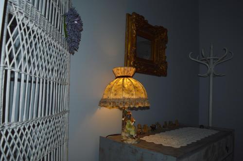 a lamp sitting on a table in a room at Pollushof Panzió és Étterem in Csolnok