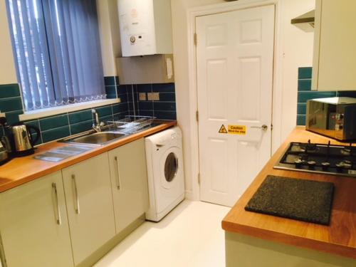 a kitchen with a washing machine and a washer and dryer at Townhouse @ Balliol Street Stoke in Stoke on Trent